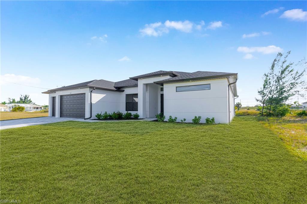 Prairie-style home featuring concrete driveway, a front lawn, a garage, and stucco siding