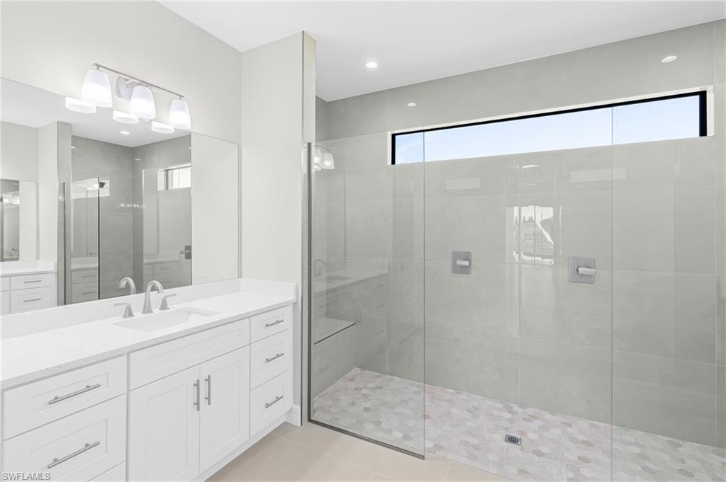 Full bath with vanity, a walk in shower, light tile patterned flooring, and recessed lighting
