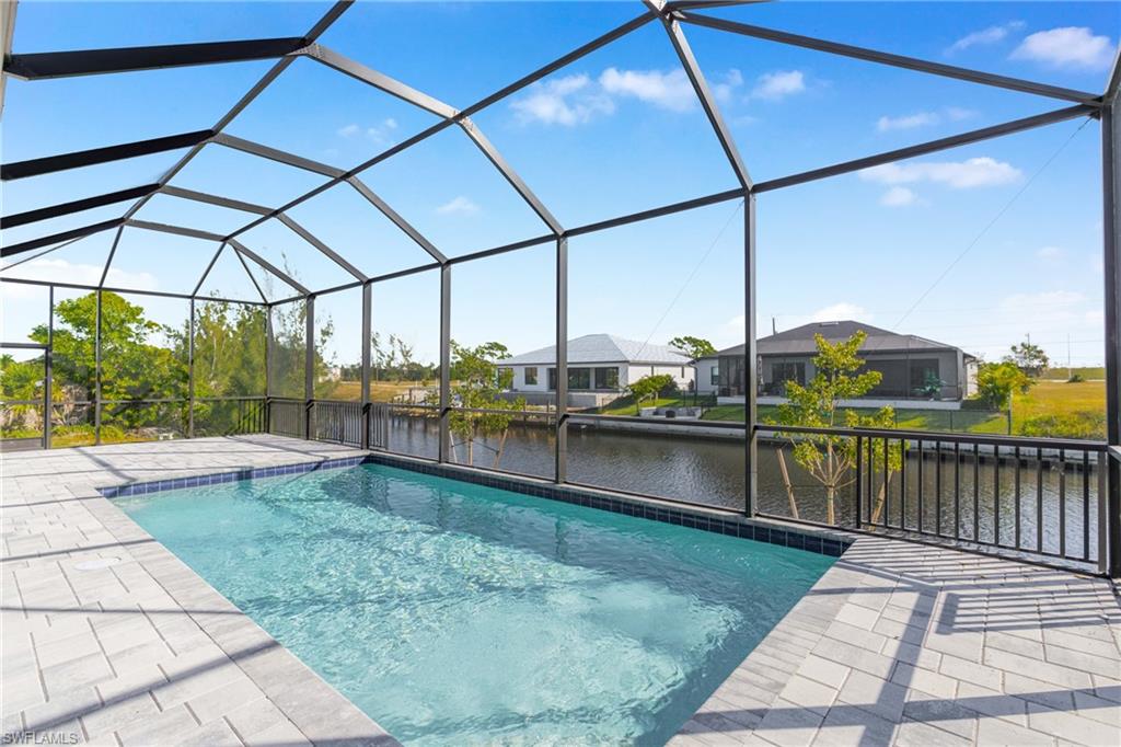 Outdoor pool featuring a sunroom, a water view, and a lanai