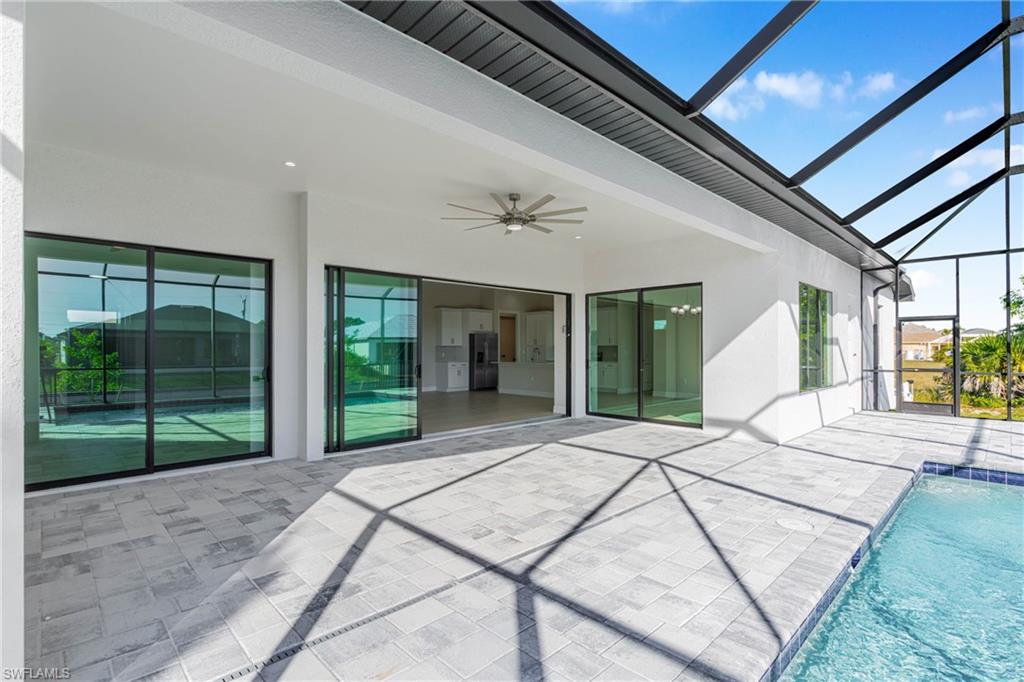 View of patio with a sunroom, a ceiling fan, a lanai, and an outdoor pool
