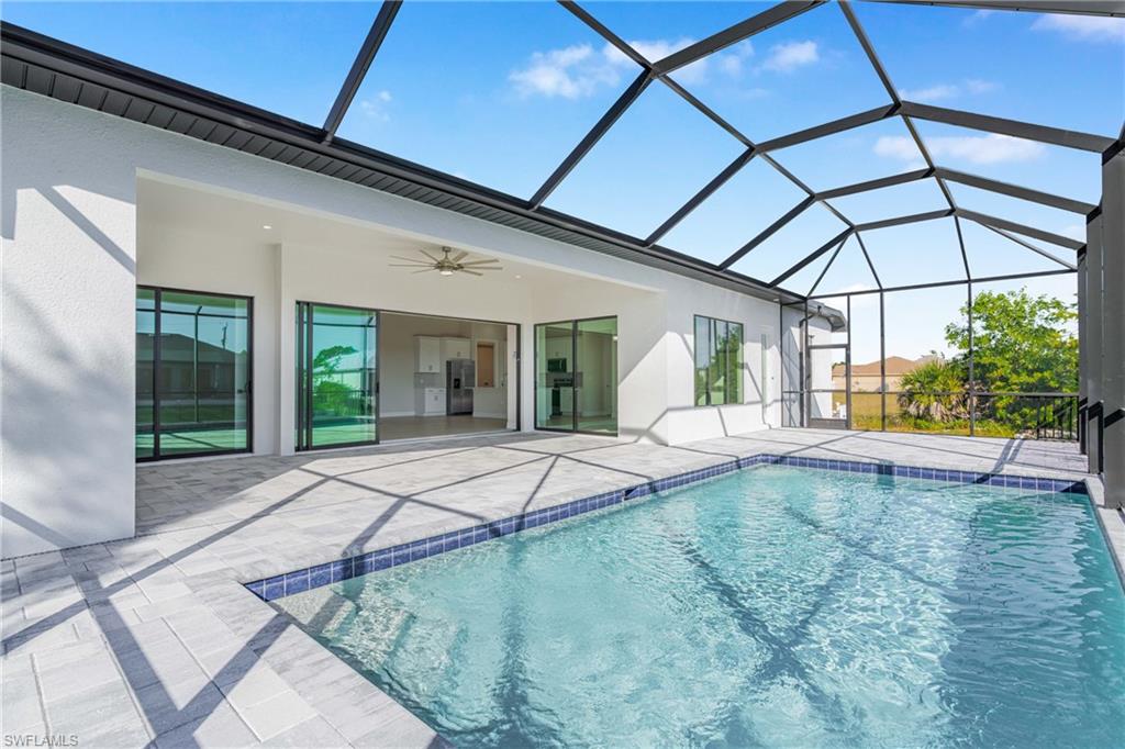 Swimming pool with a sunroom, ceiling fan, a lanai, and a patio