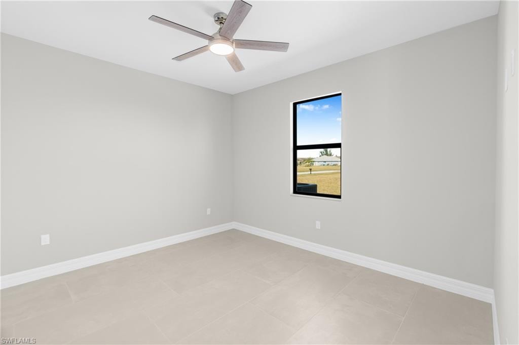 Unfurnished room with a ceiling fan and light tile patterned floors