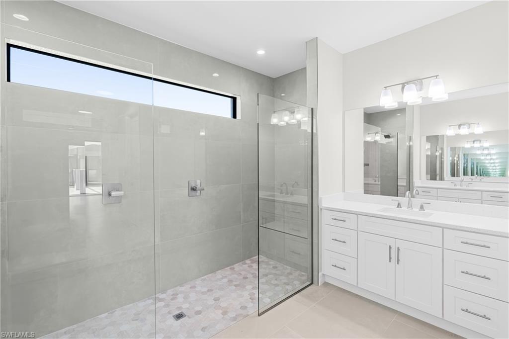 Bathroom with vanity, light tile patterned floors, a walk in shower, and recessed lighting