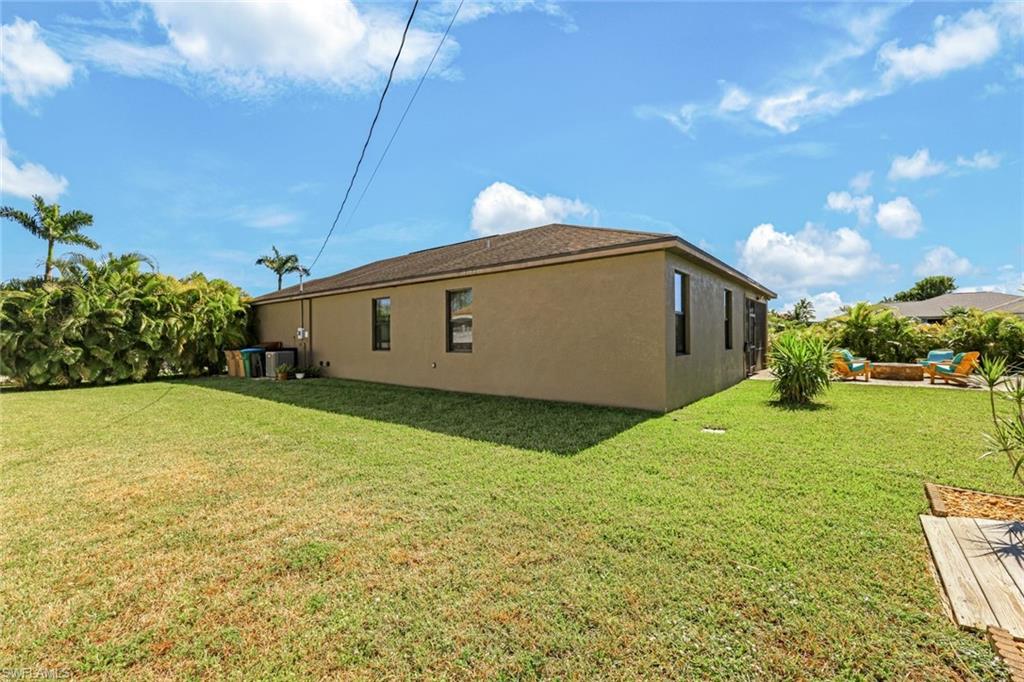 View of front facade featuring stucco siding, driveway, a garage, and a front yard