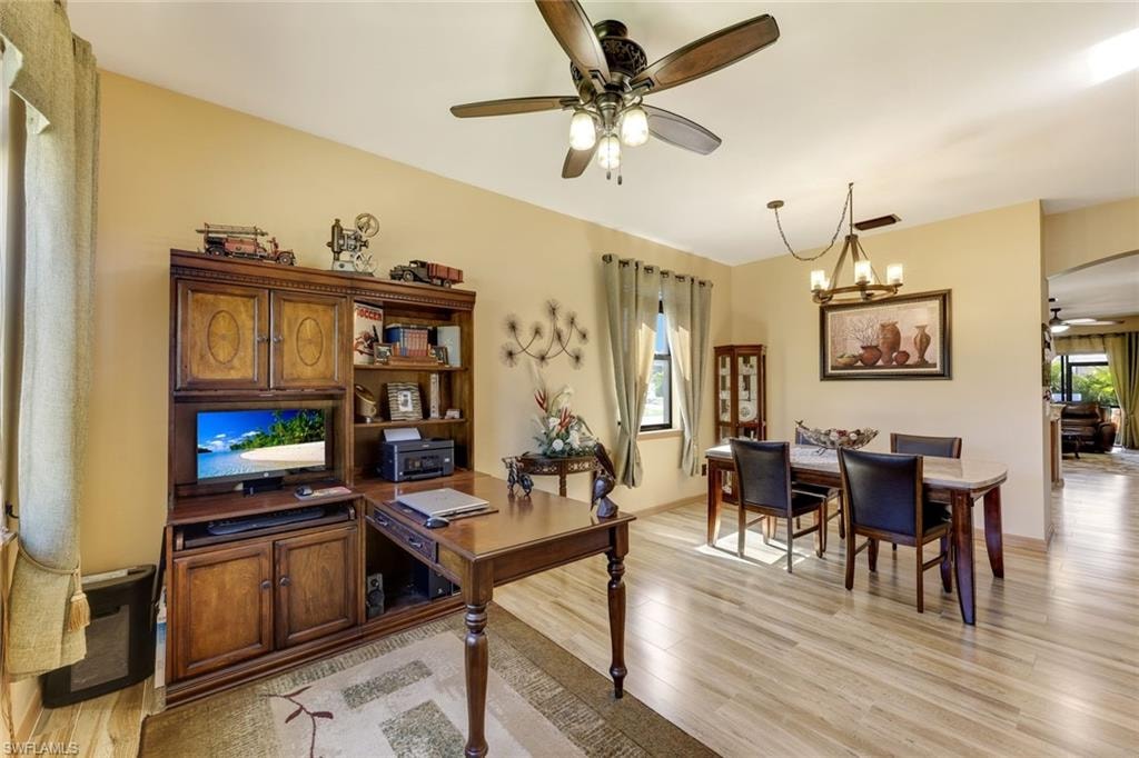 Kitchen with brown cabinets, arched walkways, appliances with stainless steel finishes, a peninsula, and a kitchen breakfast bar
