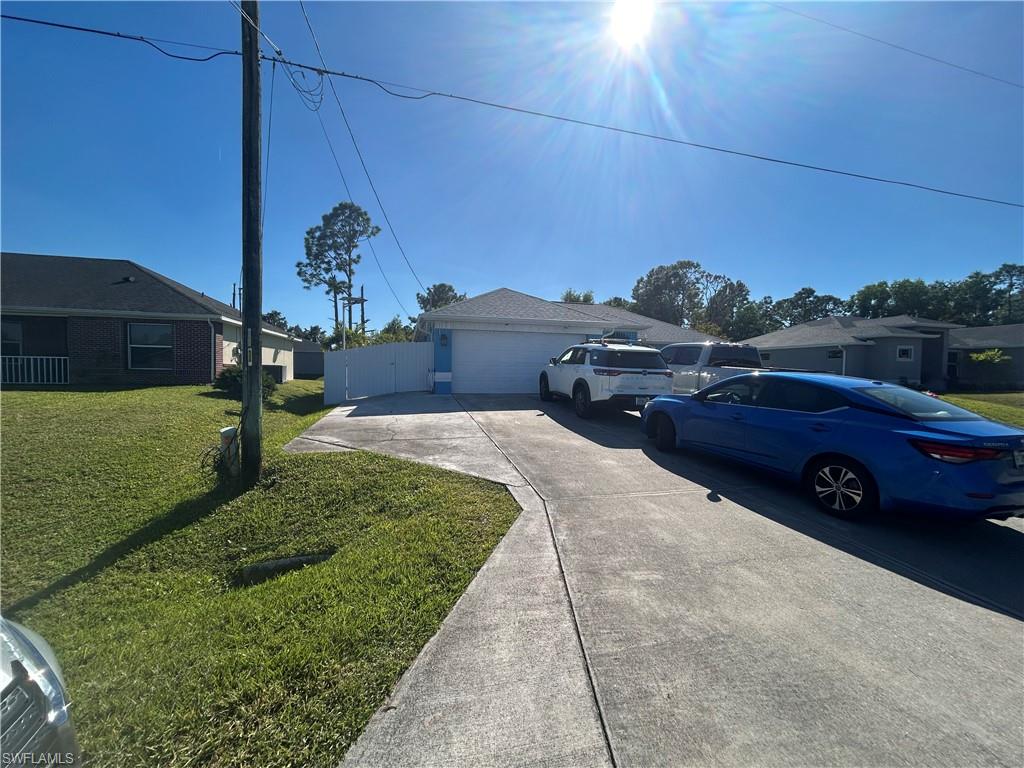 View of front of house featuring a front lawn and concrete driveway