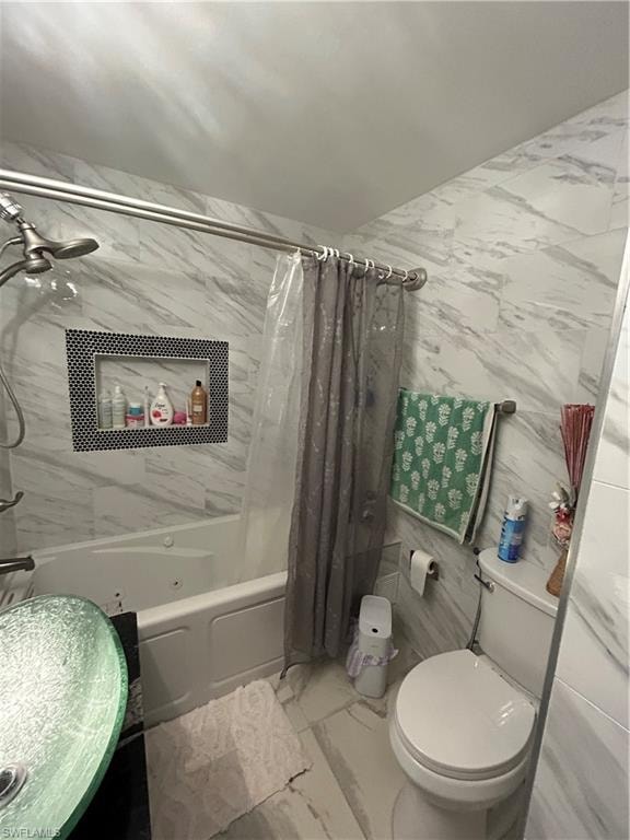Full bath featuring marble finish floors, tile walls, and shower / bath combo