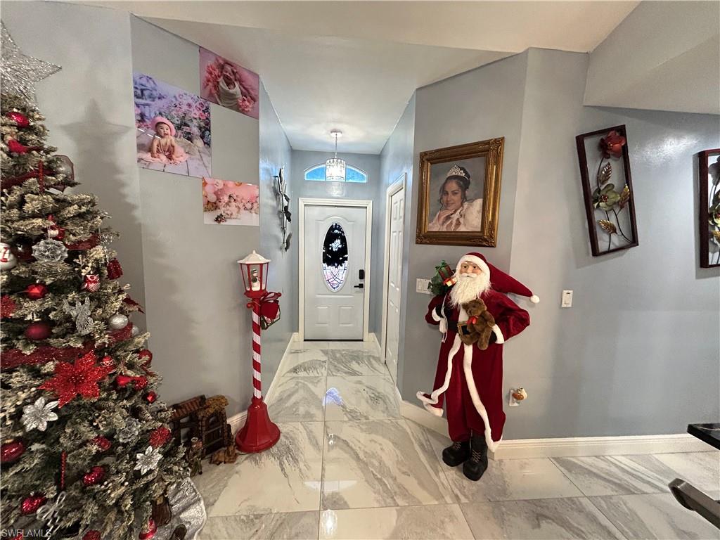 Entryway with light marble finish flooring and baseboards