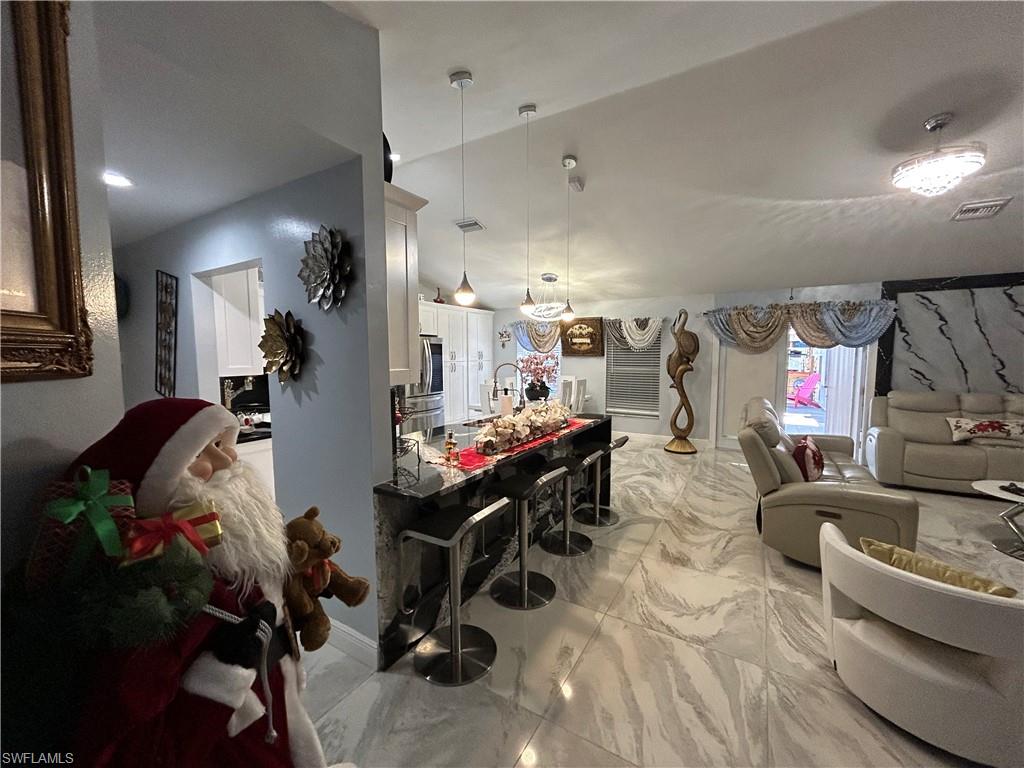 Living room featuring light marble finish flooring and baseboards
