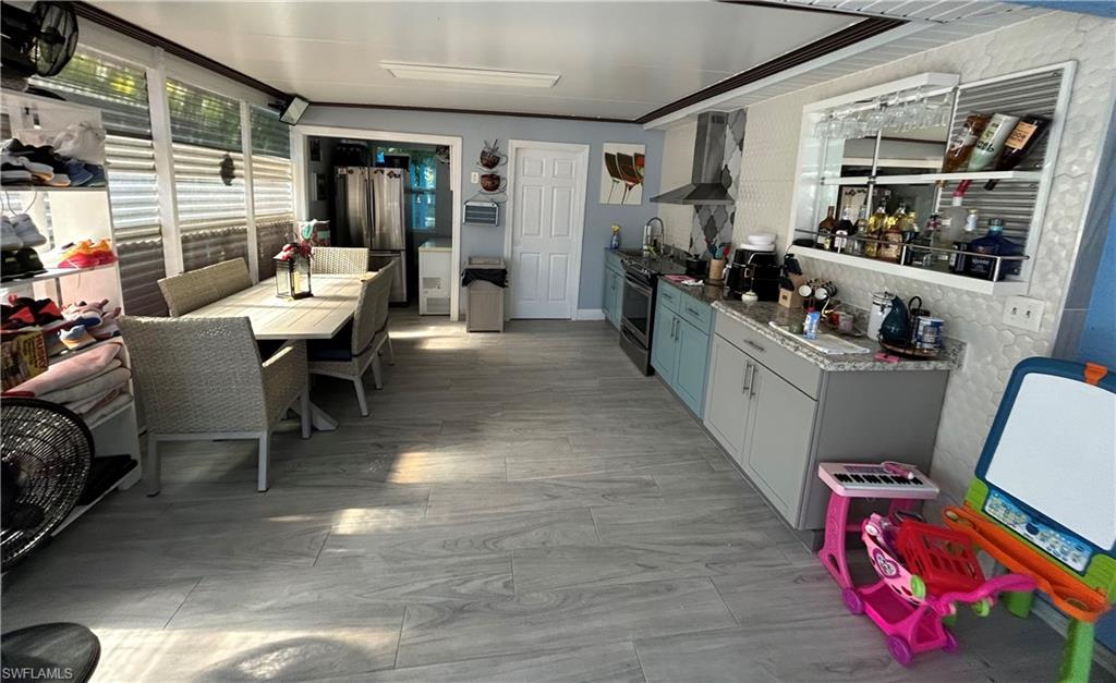 Kitchen with appliances with stainless steel finishes and wall chimney range hood
