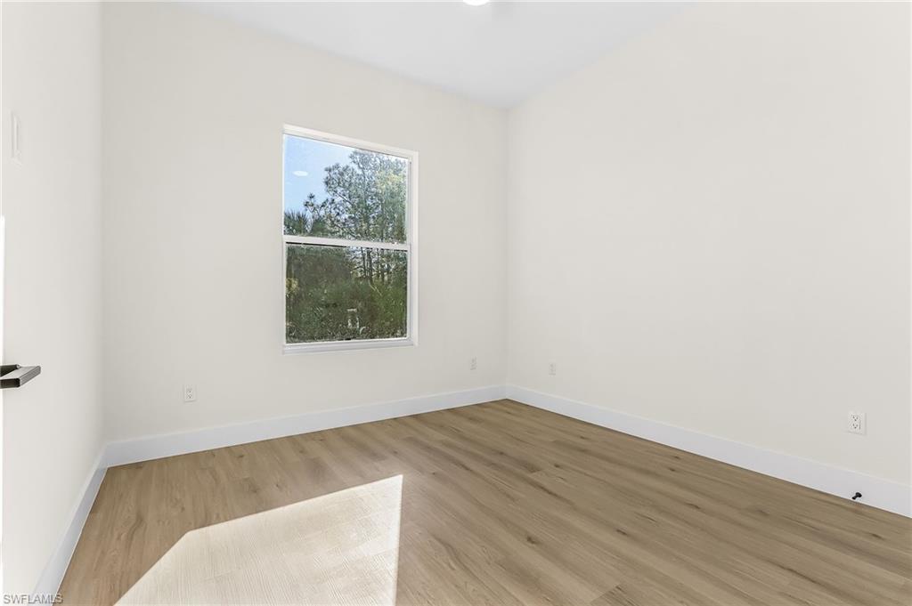 Spare room featuring wood finished floors and baseboards