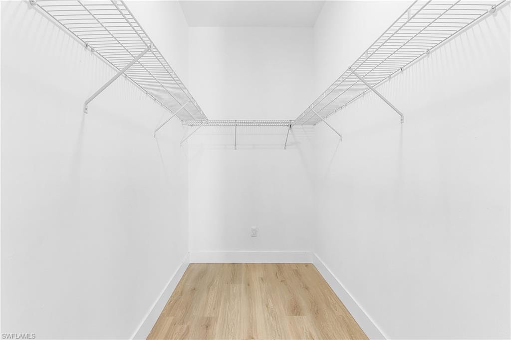 Master walk in closet featuring light wood finished floors