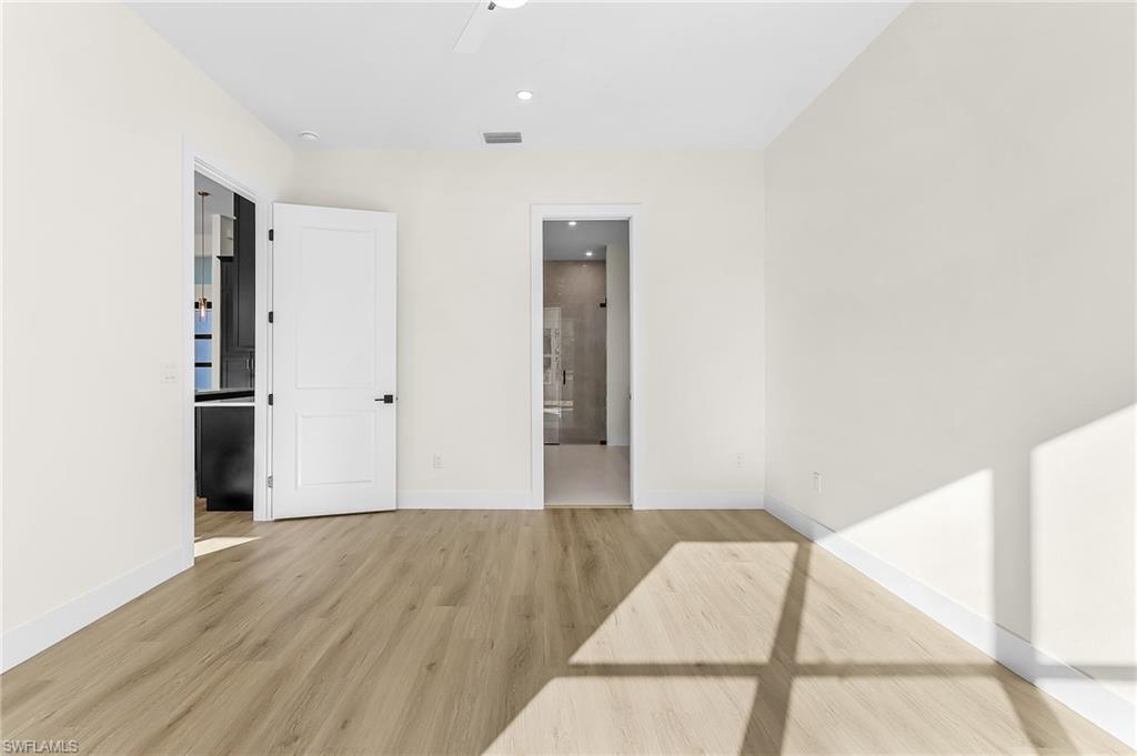 Master bedroom featuring light wood-style flooring, recessed lighting, ensuite bath, and a ceiling fan