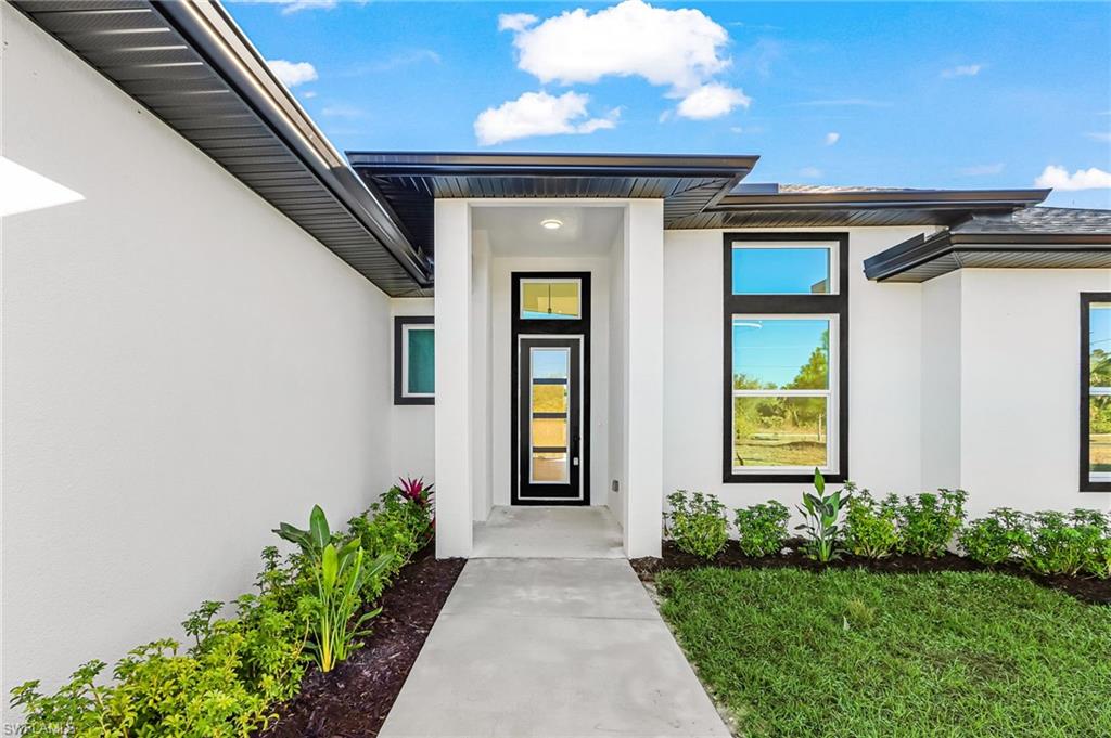 Doorway to property featuring stucco siding
