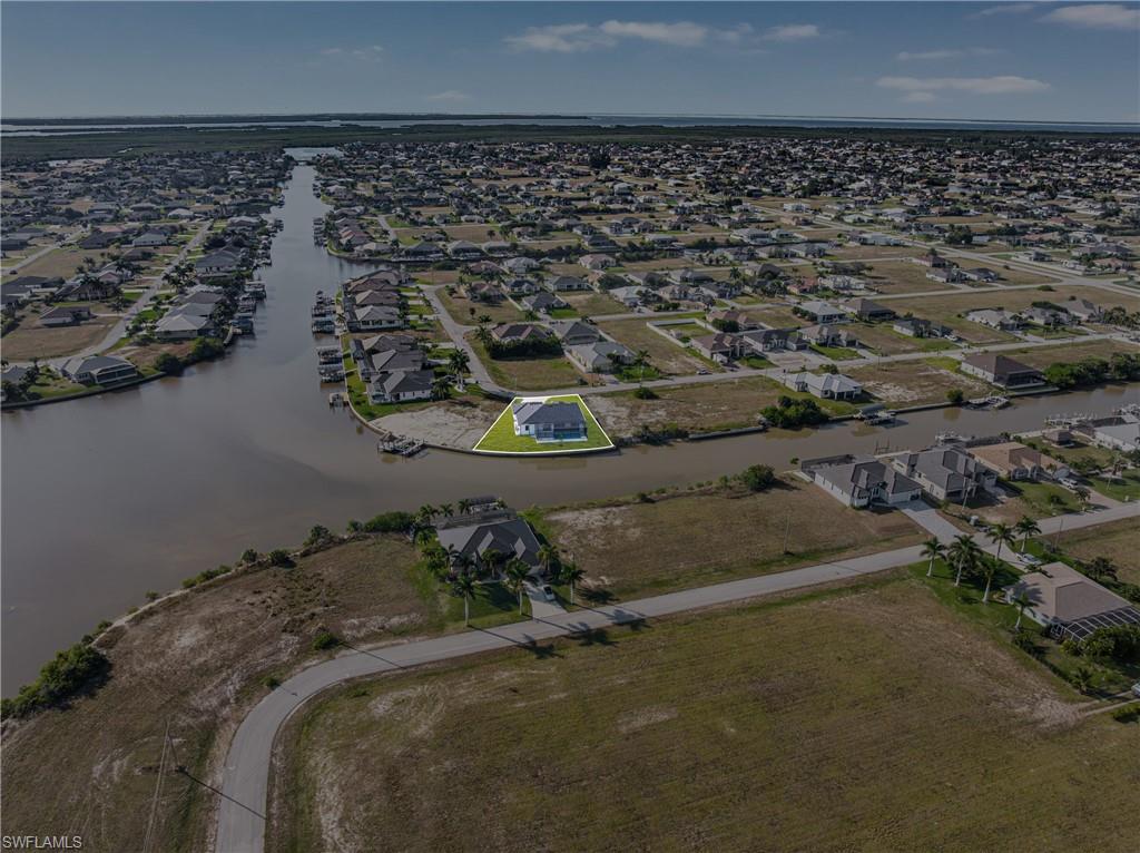 Aerial view of property's location with a nearby body of water and nearby suburban area