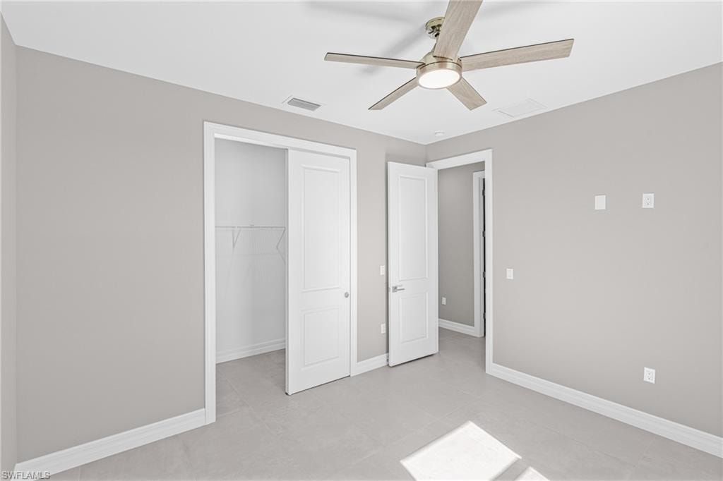 Unfurnished bedroom featuring a ceiling fan and light tile patterned floors