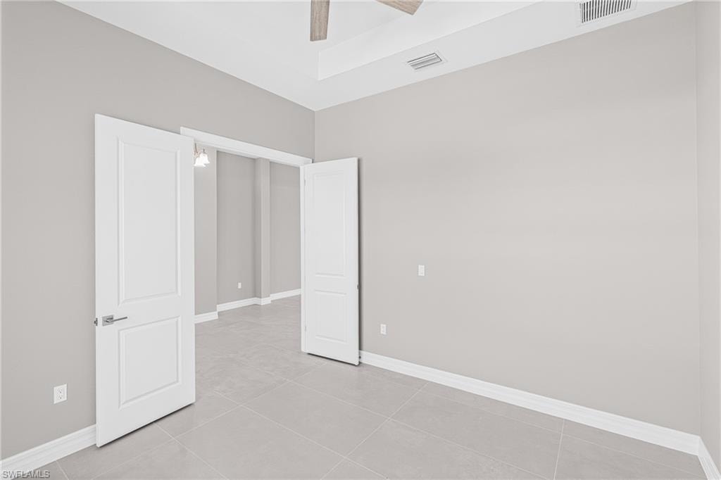 Unfurnished bedroom featuring light tile patterned floors and ceiling fan