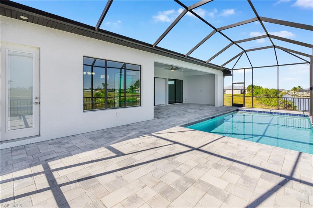 Swimming pool with a sunroom, a ceiling fan, a lanai, and a patio area