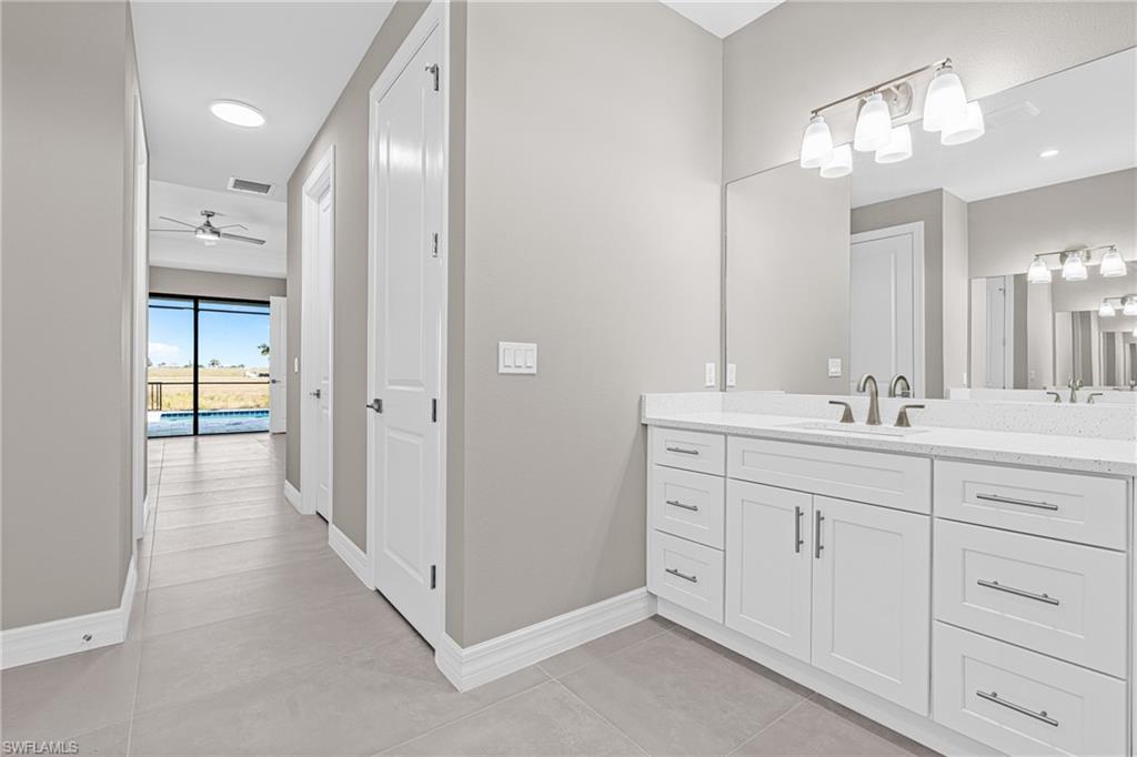 Bathroom featuring vanity, light tile patterned flooring, ceiling fan, and recessed lighting
