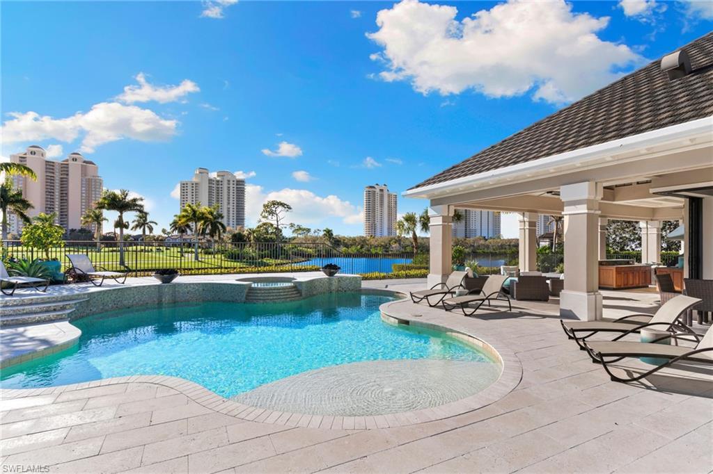 Integrated pool / hot tub featuring a patio area and a water view