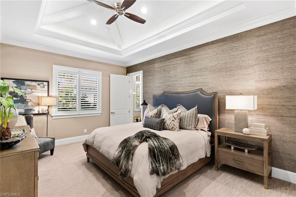 Carpeted bedroom featuring ornamental molding, an accent wall, wallpapered walls, ceiling fan, and recessed lighting