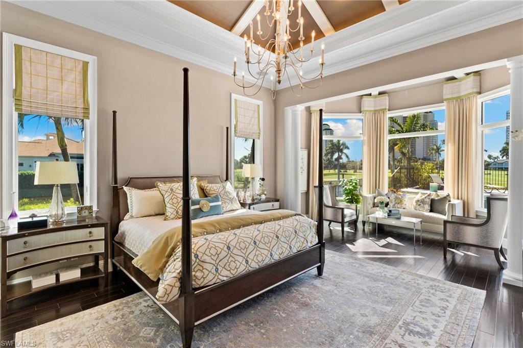 Bedroom featuring dark wood-style flooring, multiple windows, a chandelier, and ornamental molding