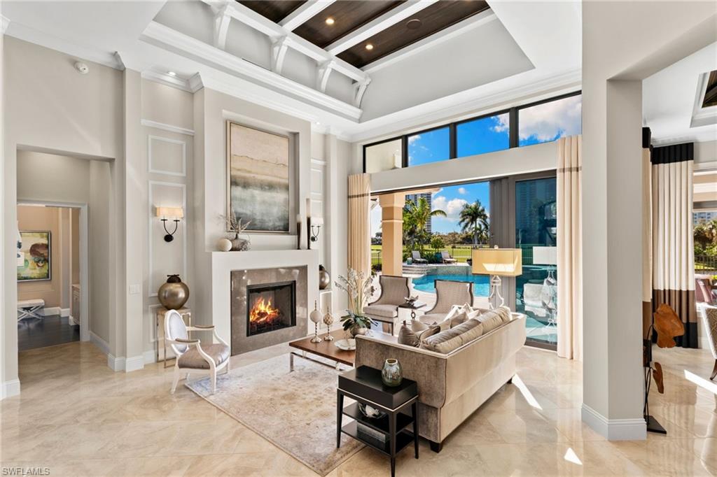 Living area featuring a tile fireplace, crown molding, recessed lighting, and custom ceiling