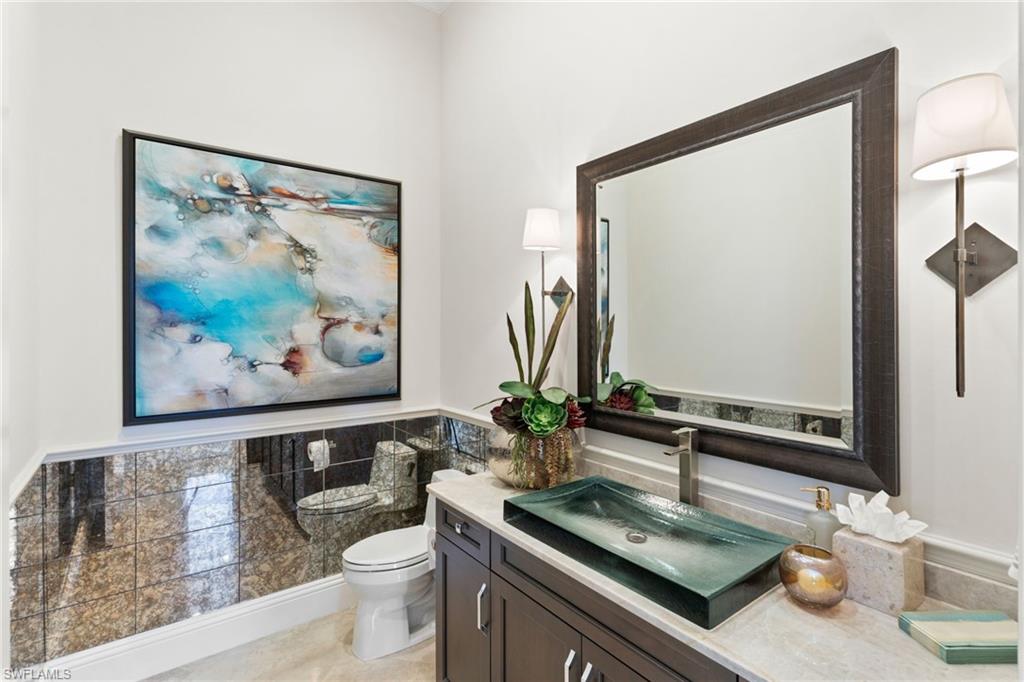 Bathroom featuring vanity, tile walls, and a wainscoted wall