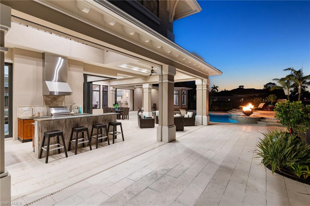 View of patio / terrace featuring an outdoor lounge area with bar, exterior kitchen, and a pool with connected hot tub