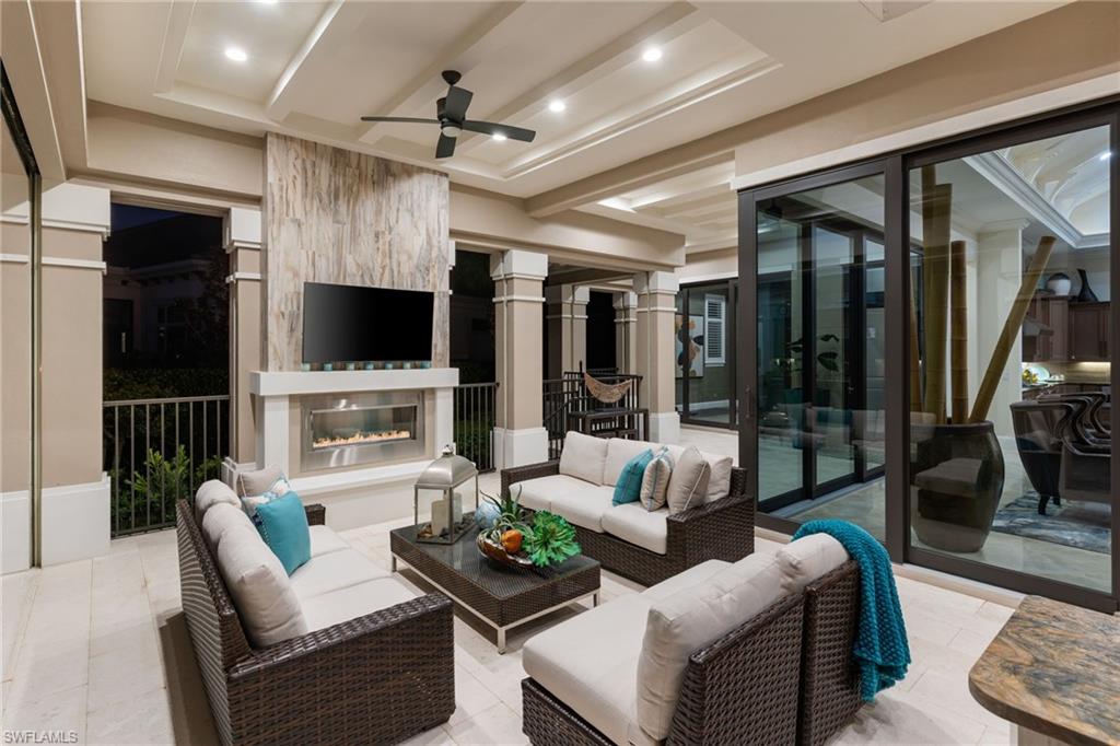 View of patio / terrace with a ceiling fan and an outdoor living space with a fireplace