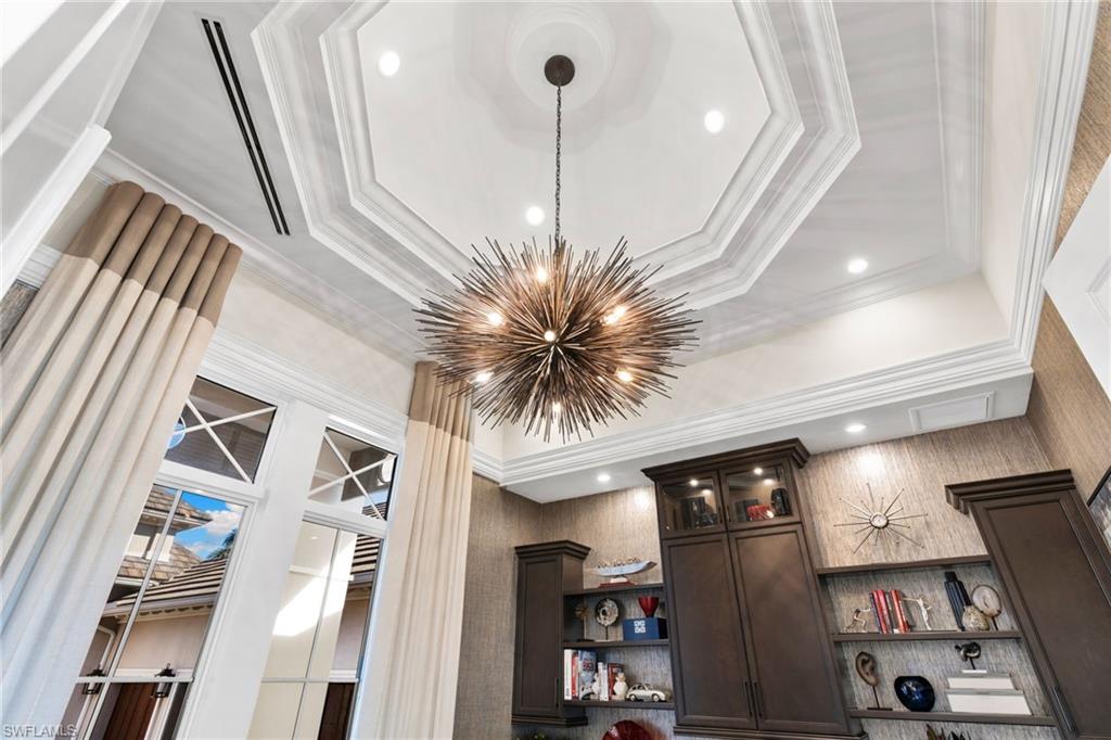 Detailed view of a chandelier, ornamental molding, and custom ceiling
