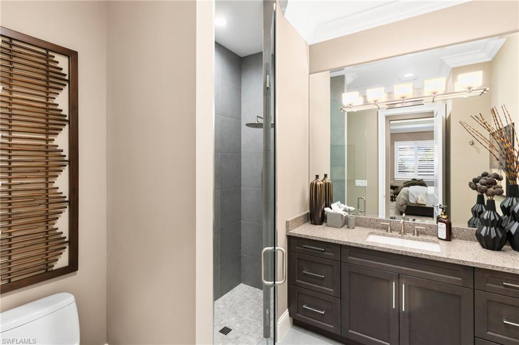 Full bath with vanity, a stall shower, recessed lighting, ensuite bath, and ornamental molding