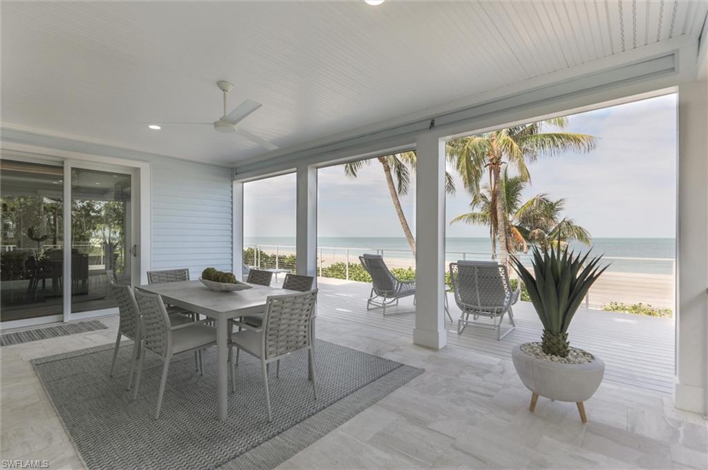 Sunroom with ceiling fan and a water view