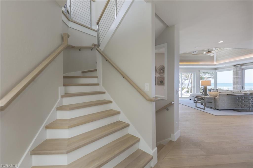 Stairs featuring hardwood / wood-style floors and a raised ceiling