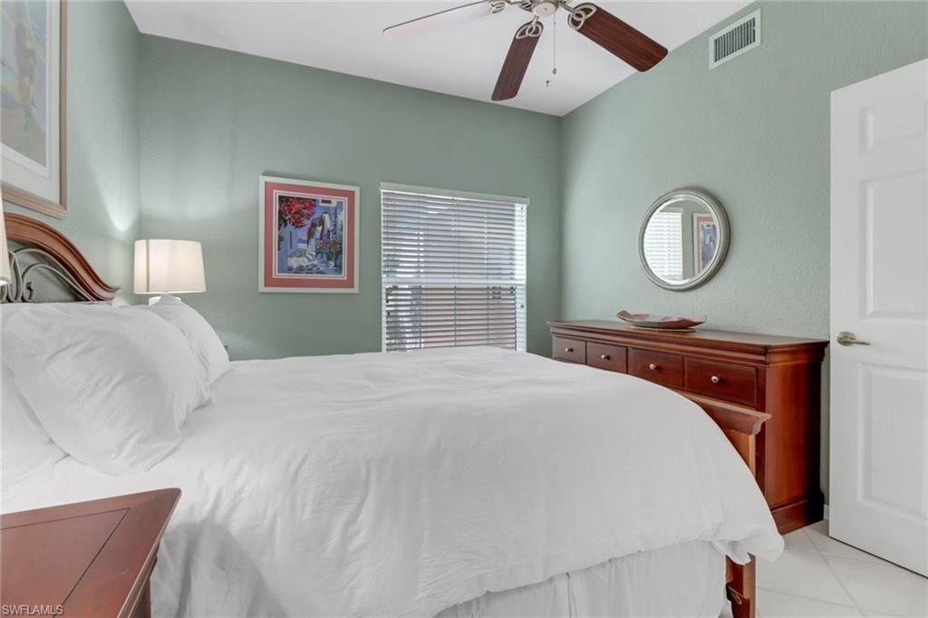 Bedroom with ceiling fan and light tile patterned flooring