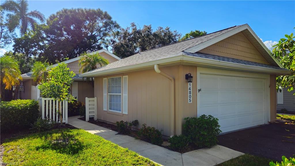 View of side of property featuring a shingled roof and an attached garage