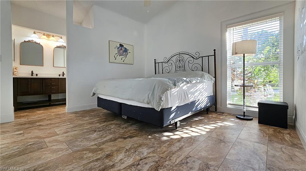 Bedroom featuring baseboards and ensuite bathroom