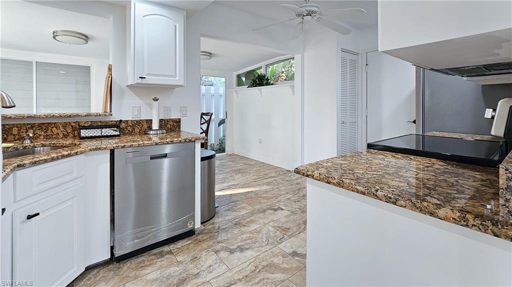Kitchen featuring white cabinets, dark stone countertops, dishwasher, electric range, and ceiling fan