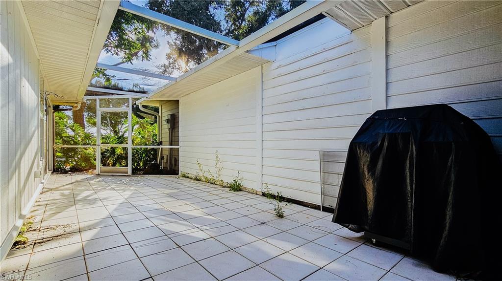 View of patio / terrace featuring a lanai, a sunroom, and grilling area