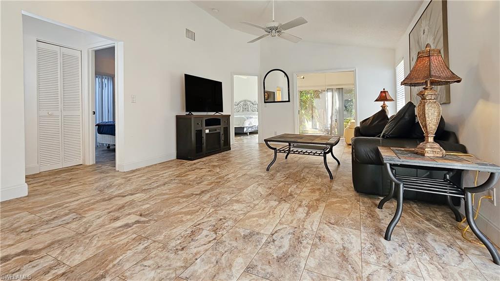 Living area with a ceiling fan and high vaulted ceiling