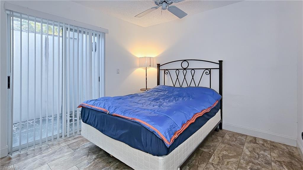 Bedroom featuring ceiling fan and a textured ceiling