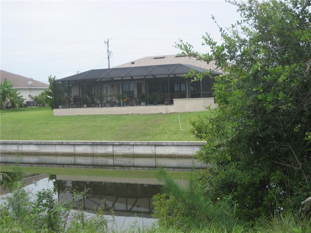 Rear view of house featuring a sunroom, a lanai, and a yard