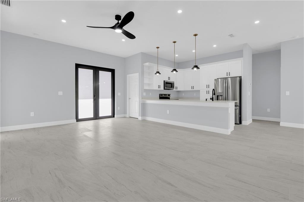 Unfurnished living room with recessed lighting, french doors, and a ceiling fan