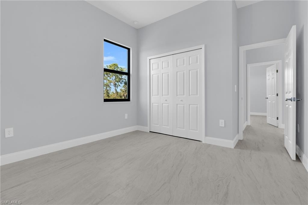 Unfurnished bedroom with a closet and light carpet