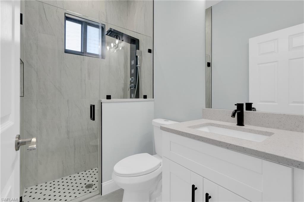Bathroom with a marble finish shower and vanity