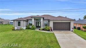 View of front of home featuring driveway, a front lawn, and a garage