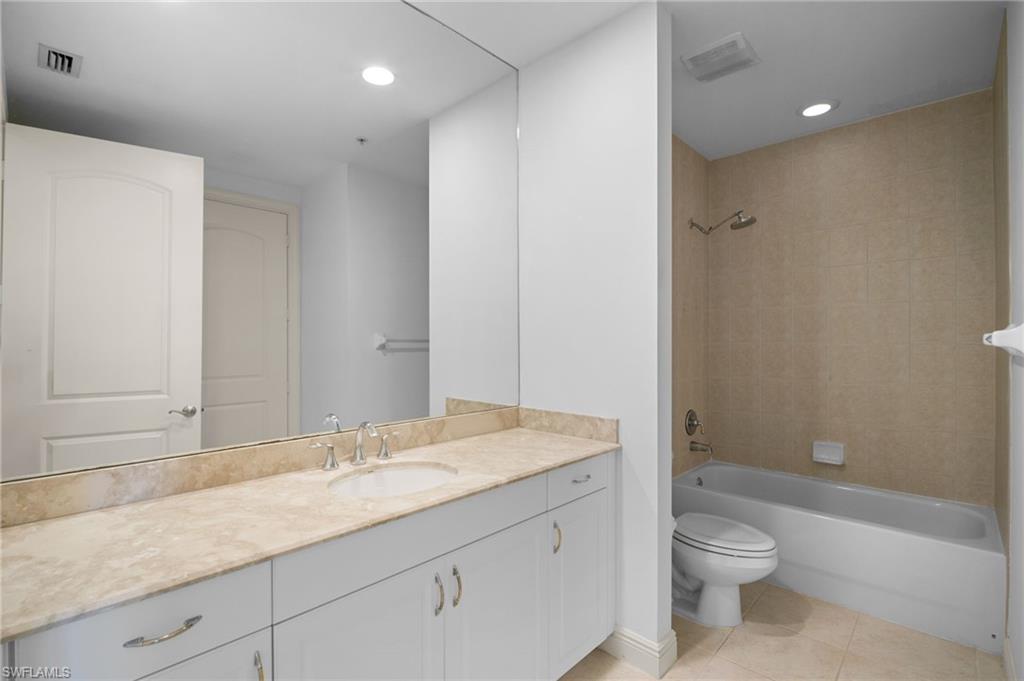 Bathroom with vanity, bathing tub / shower combination, light tile patterned floors, and recessed lighting