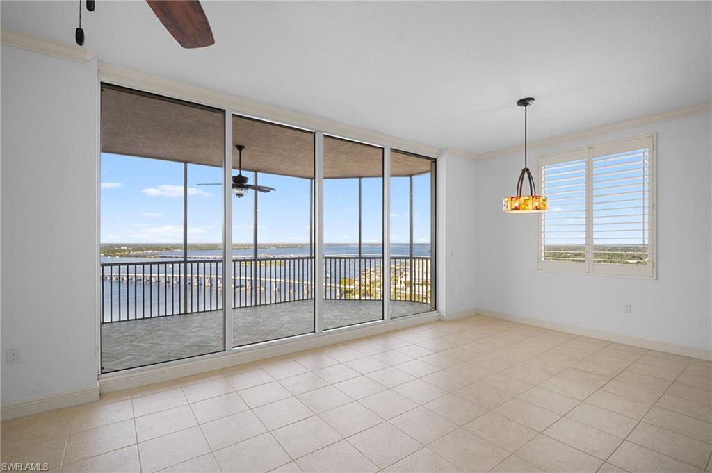 Spare room featuring light tile patterned flooring, ornamental molding, ceiling fan, and a water view