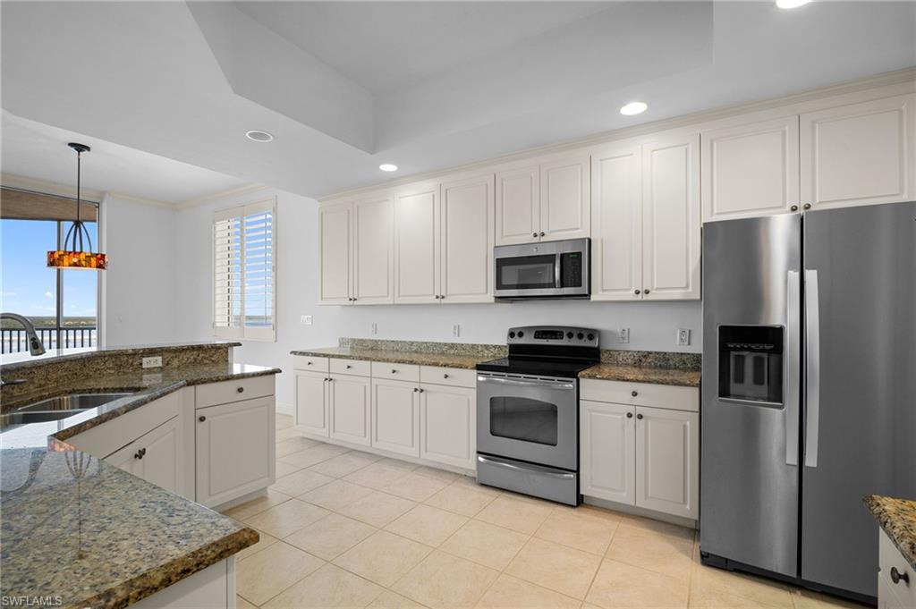 Kitchen with stainless steel appliances, recessed lighting, light tile patterned flooring, pendant lighting, and ornamental molding