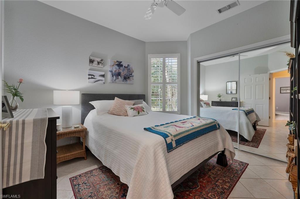 Bedroom with a closet, ceiling fan, and light tile patterned floors
